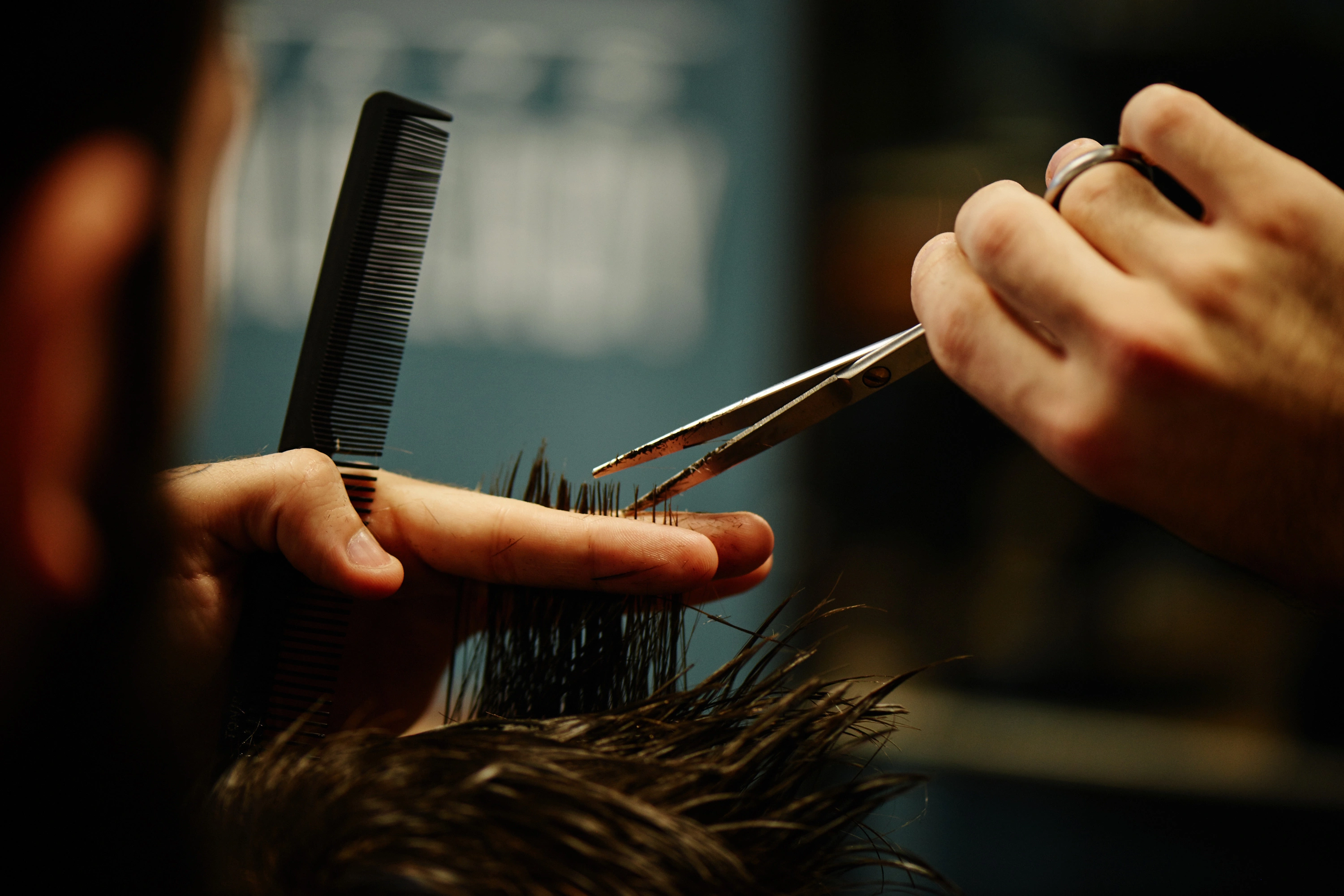 Barber cutting hair with scissors at Master Barber NYC in Brooklyn